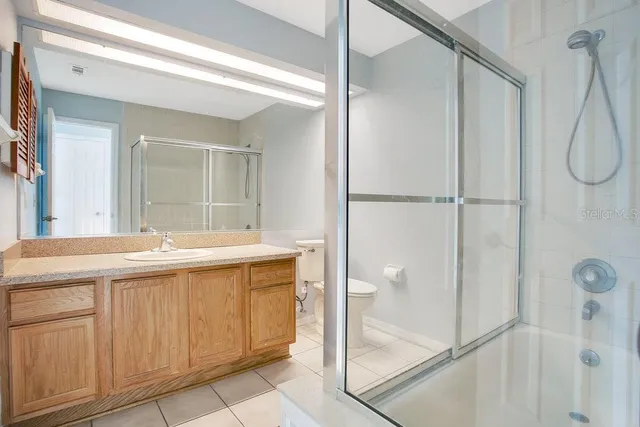 a bathroom with a granite countertop sink a mirror and a shower