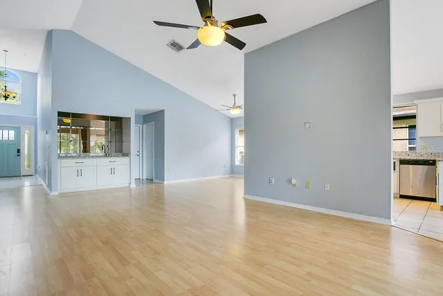 a view of an empty room with window and wooden floor