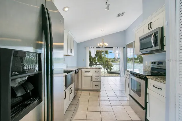 a kitchen with stainless steel appliances granite countertop a refrigerator and a stove top oven