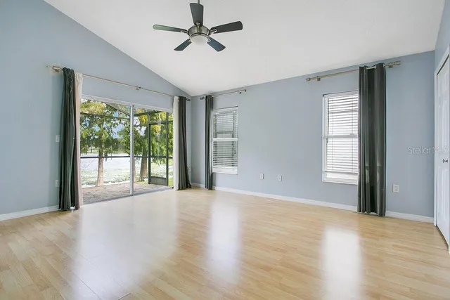 a view of an empty room with a window and wooden floor