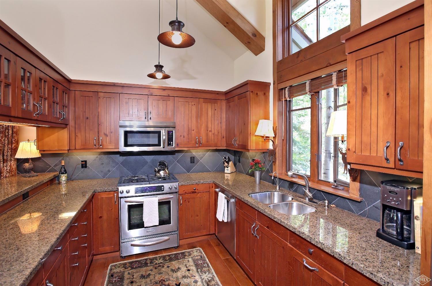 404 Cresta Road Edwards, CO 81632 - Photo 6 of 24 a kitchen with stainless steel appliances granite countertop a stove a sink dishwasher and a microwave oven with cabinets