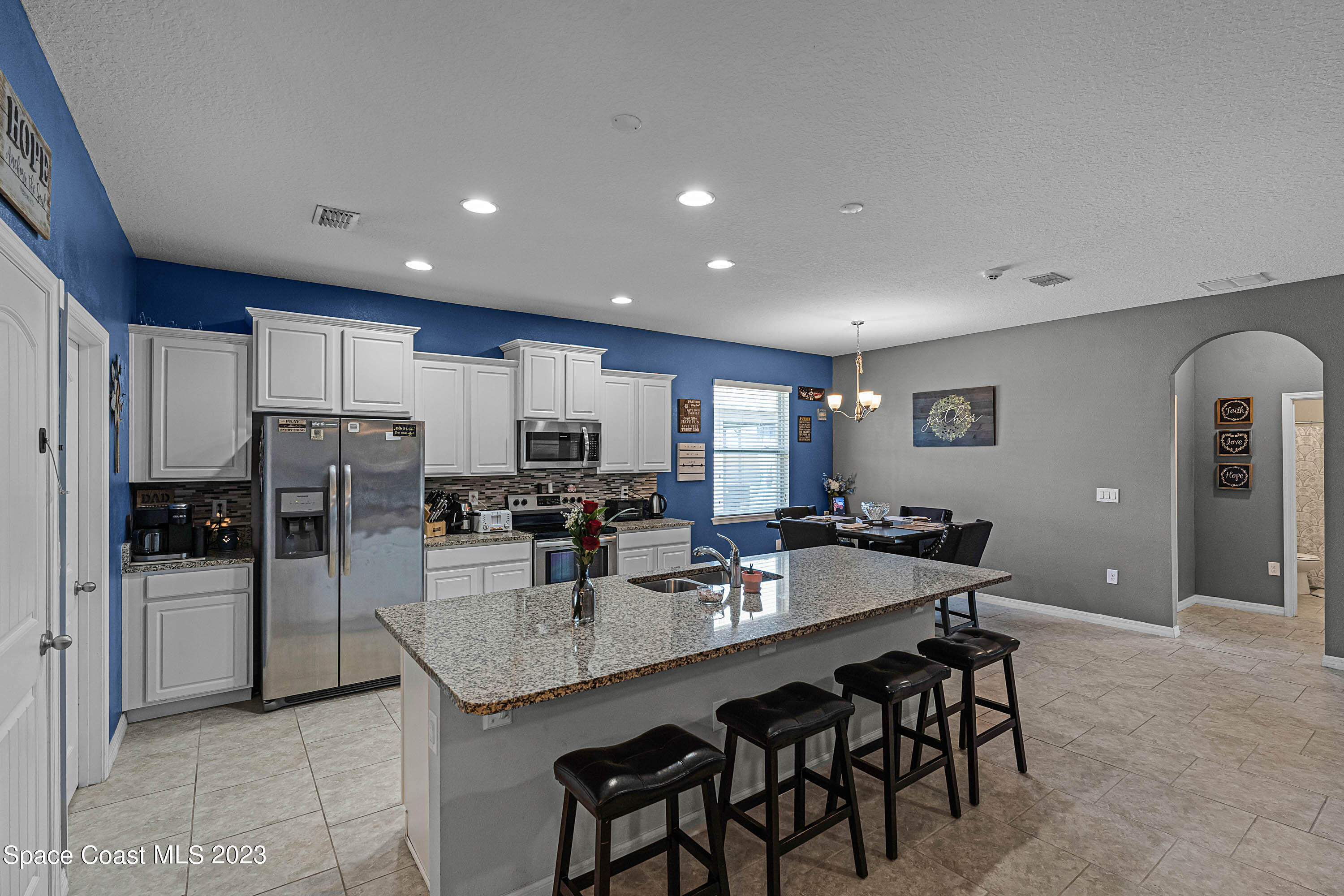 1803 Brockridge Road Kissimmee, FL 34744 - Photo 13 of 46 a kitchen with granite countertop a refrigerator a stove a sink a dining table and chairs