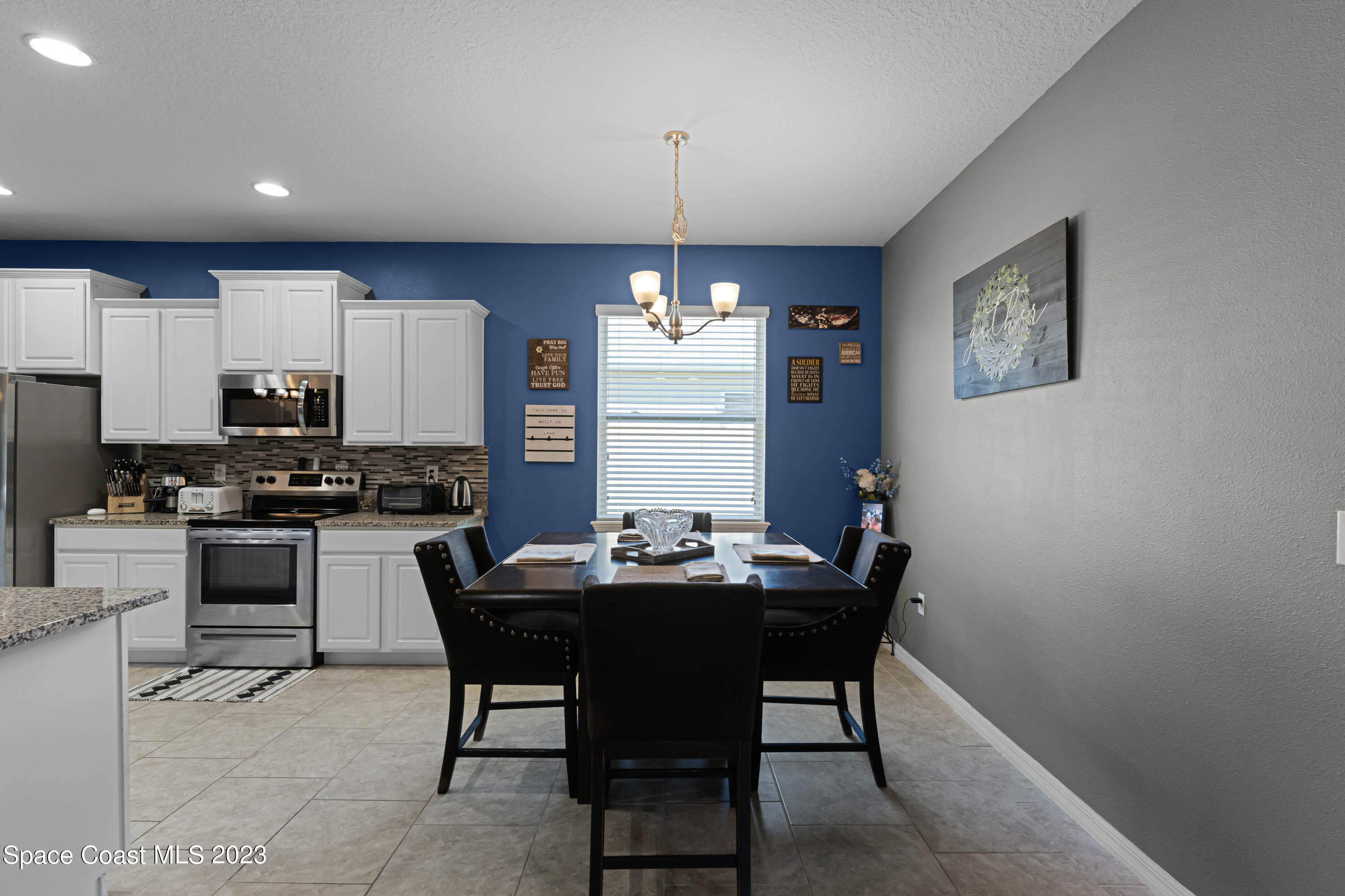 1803 Brockridge Road Kissimmee, FL 34744 - Photo 15 of 46 a kitchen with a dining table chairs stainless steel appliances and cabinets