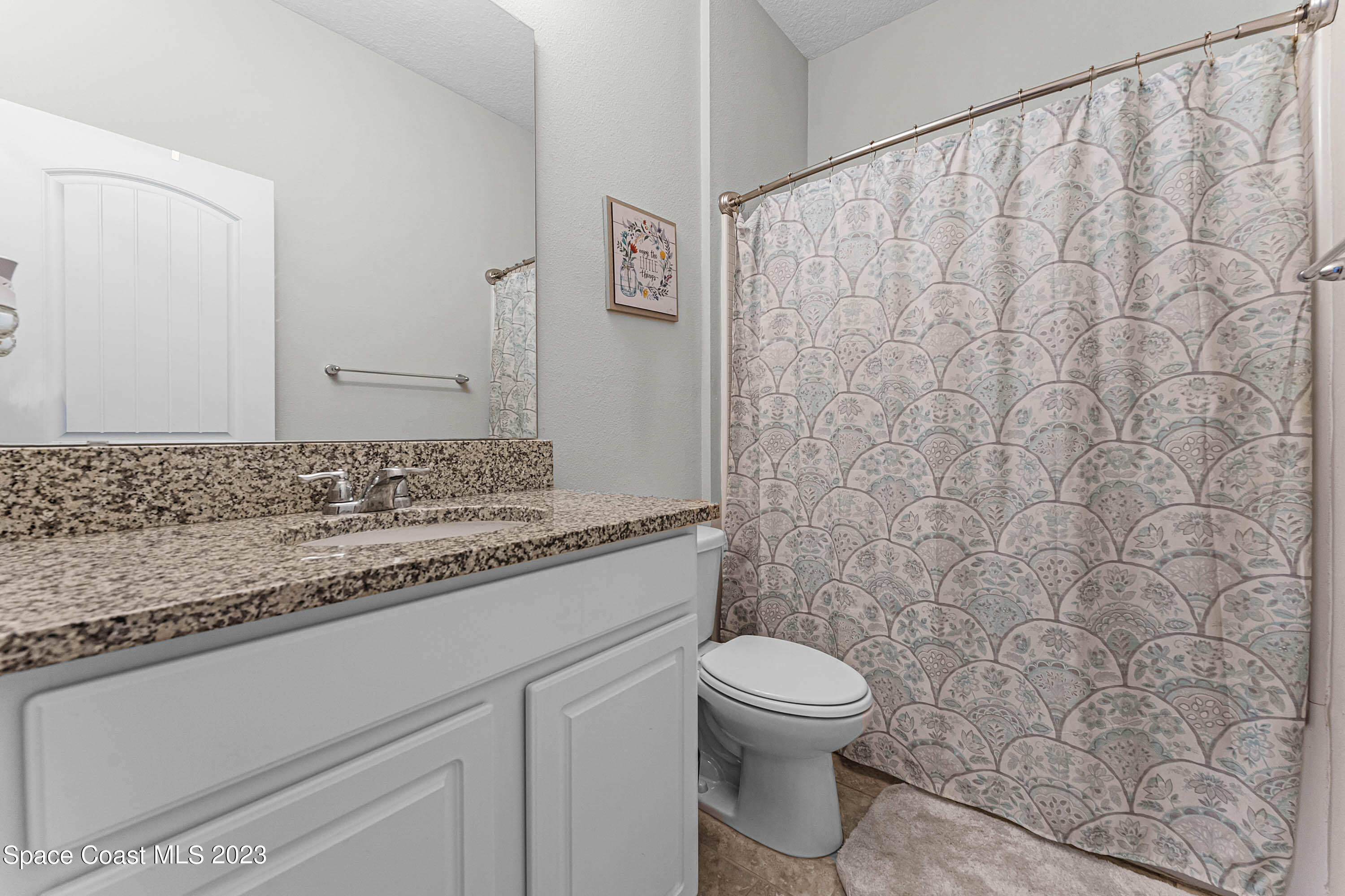 1803 Brockridge Road Kissimmee, FL 34744 - Photo 29 of 46 a bathroom with a granite countertop sink a toilet and a shower