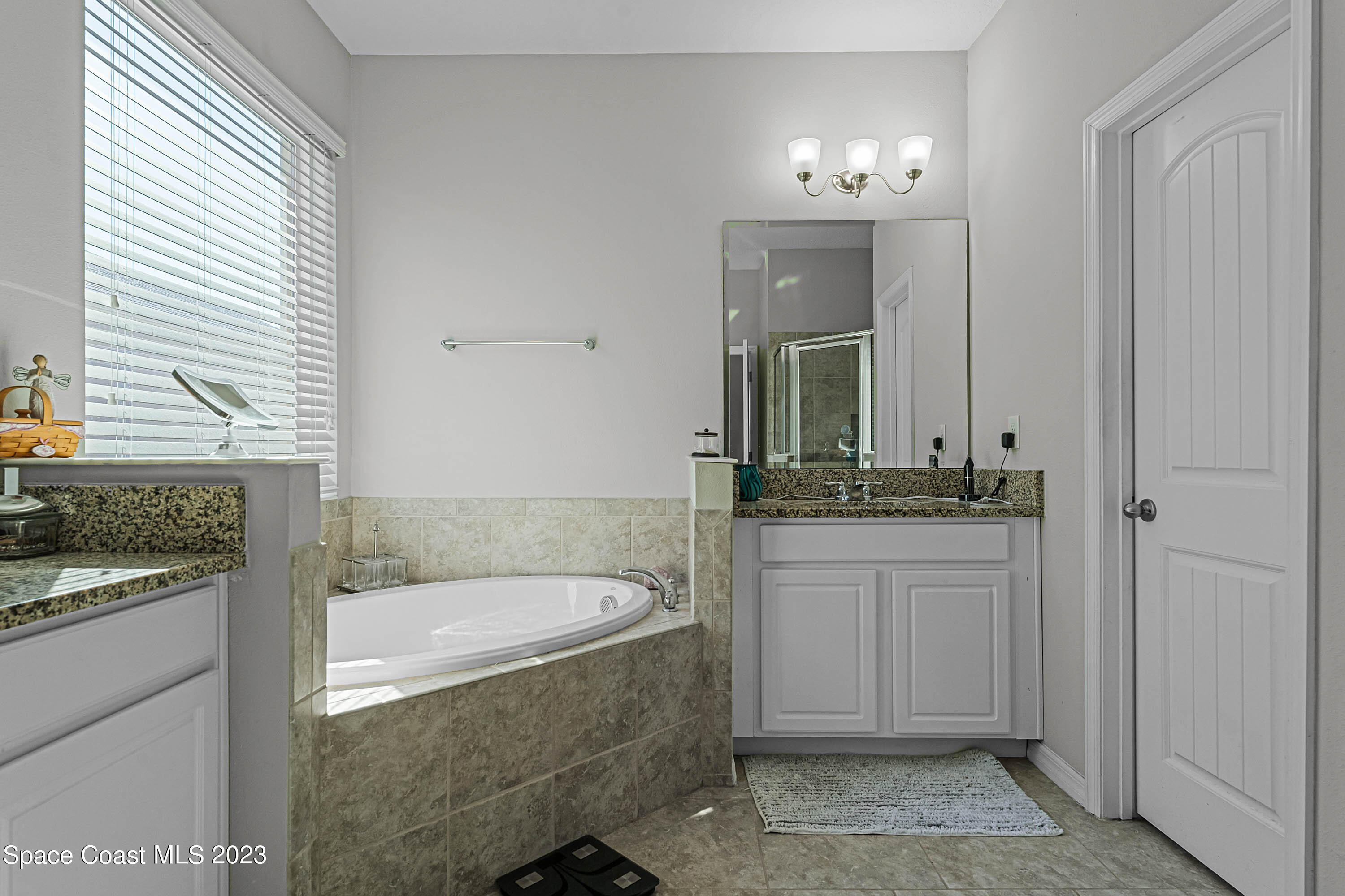 1803 Brockridge Road Kissimmee, FL 34744 - Photo 32 of 46 a bathroom with a granite countertop sink and a mirror