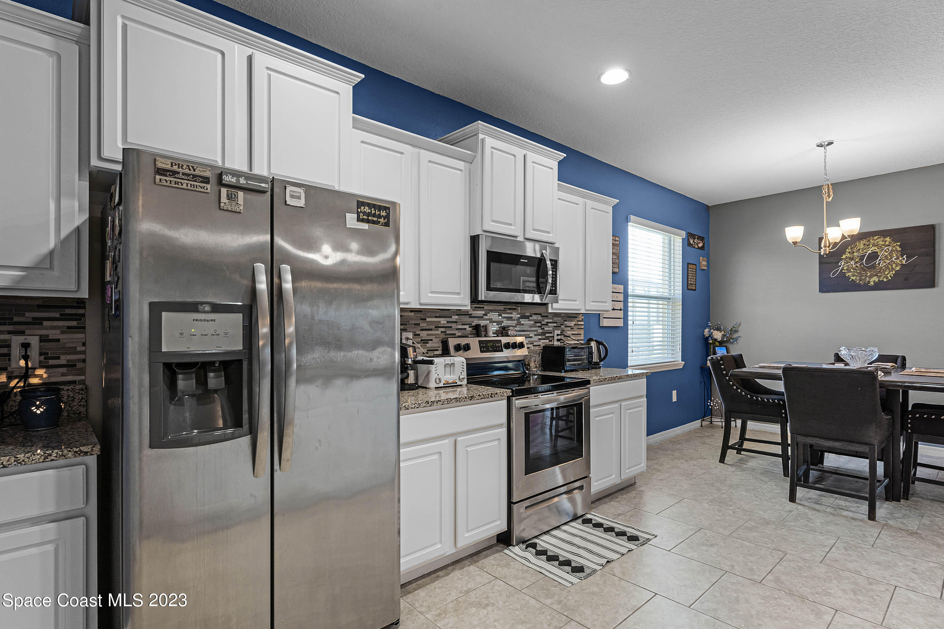 1803 Brockridge Road Kissimmee, FL 34744 - Photo 34 of 46 a kitchen with granite countertop a refrigerator oven a sink a dining table and chairs