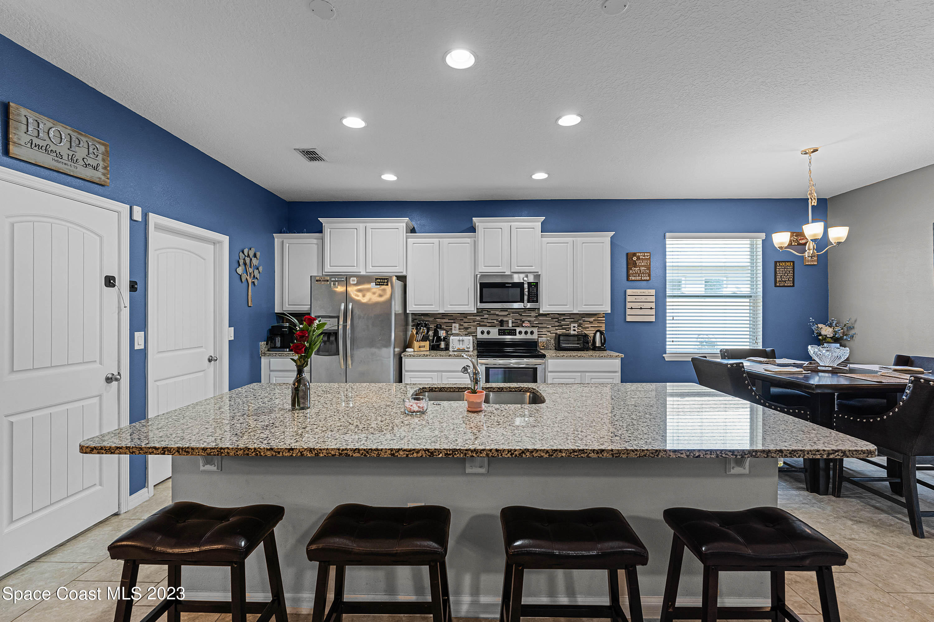 1803 Brockridge Road Kissimmee, FL 34744 - Photo 35 of 46 a kitchen with granite countertop a table chairs microwave and cabinets