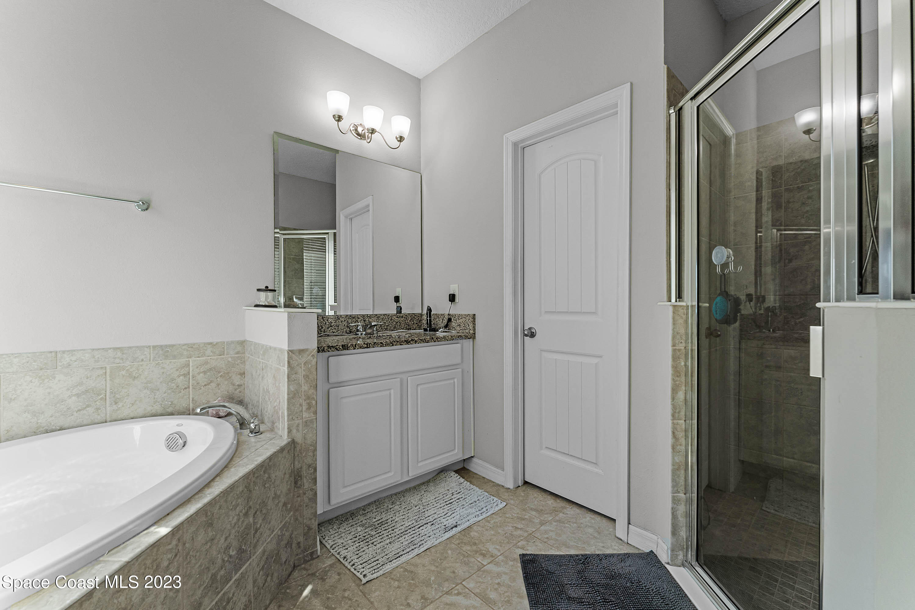 1803 Brockridge Road Kissimmee, FL 34744 - Photo 9 of 46 a bathroom with a tub a sink shower and mirror