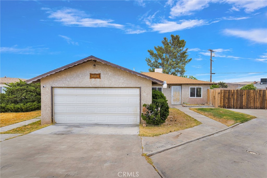 2567 Perth Court Barstow, CA 92311 - Photo 4 of 56 a front view of a house with a yard and garage