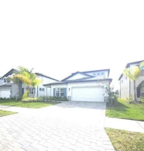 a front view of a house with a yard and potted plants