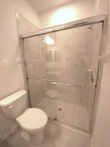 a view of an empty room with a chandelier fan