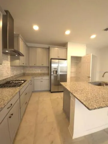 a large kitchen with stainless steel appliances granite countertop a sink stove and refrigerator