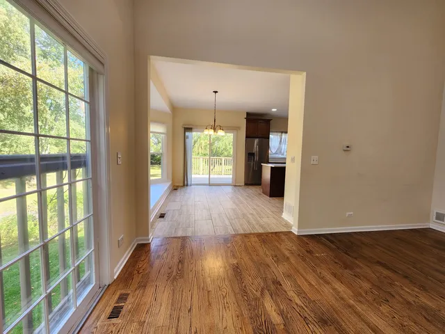 a view of a big room with wooden floor and windows