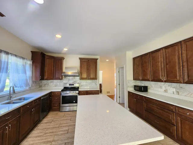 a kitchen with stainless steel appliances a sink stove and cabinets