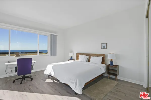 a bedroom with a bed a table and chair