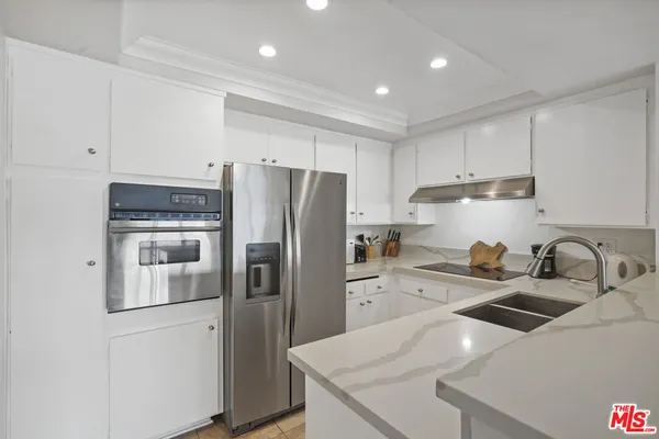 a kitchen with stainless steel appliances a refrigerator sink and cabinets