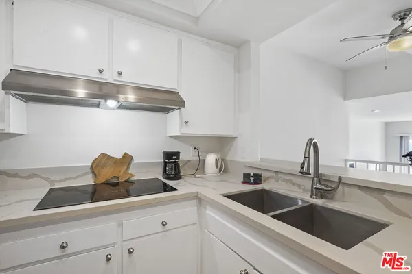 a kitchen with stainless steel appliances a sink a stove and cabinets