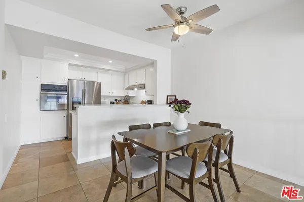 a kitchen with stainless steel appliances a table and chairs in it