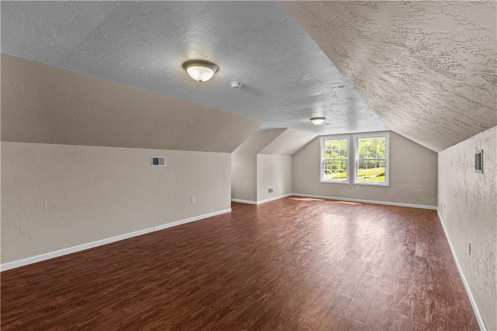509 Quail Hill Road Normalville, PA 15469 - Photo 17 of 26 an empty room with wooden floor and windows