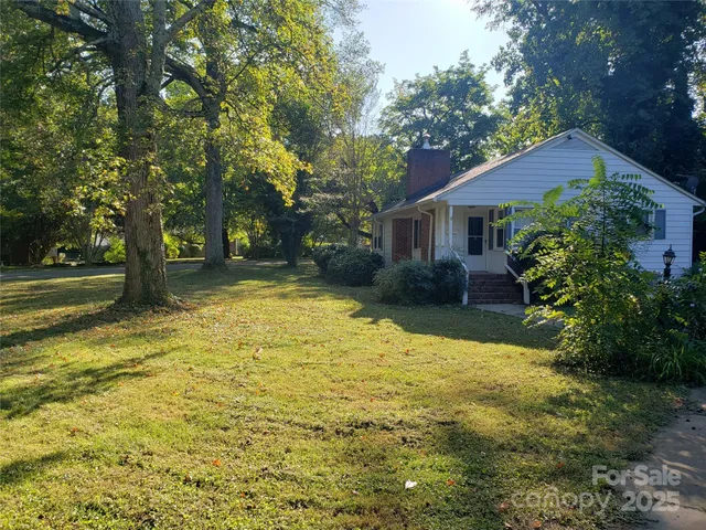 a view of a house with pool and trees