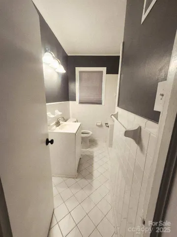 a bathroom with a sink a toilet and mirror