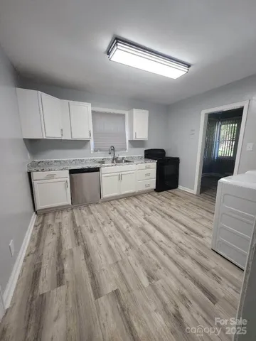 a large kitchen with a lot of cabinets and wooden floor