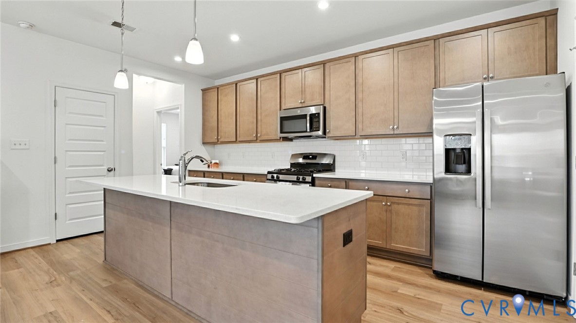 a kitchen with stainless steel appliances a refrigerator sink and microwave