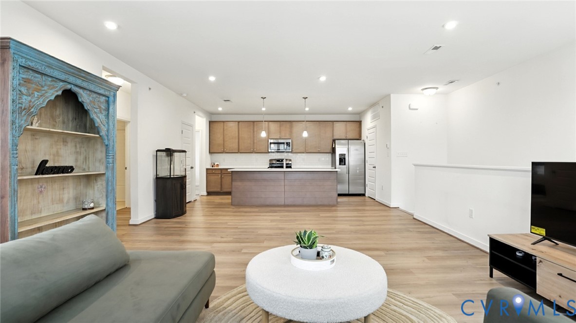 12109 Oxford Landing Drive, Unit 201 Glen Allen, VA 23059 - Photo 12 of 26 a living room with stainless steel appliances furniture and a kitchen view