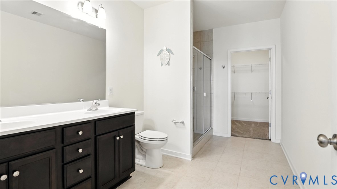 12109 Oxford Landing Drive, Unit 201 Glen Allen, VA 23059 - Photo 22 of 26 a spacious bathroom with a double vanity sink toilet mirror and shower