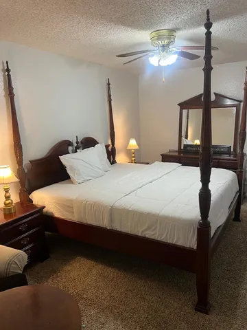 a bedroom with bed and a chandelier