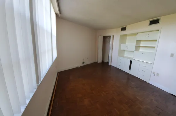 a view of empty room with wooden floor