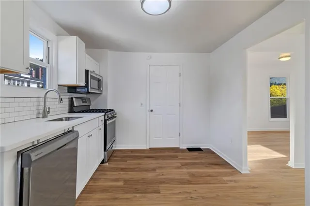 a kitchen with stainless steel appliances granite countertop a stove a sink and a refrigerator