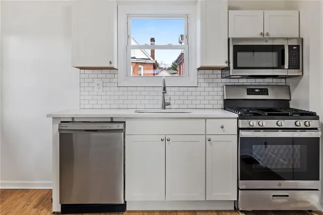 a kitchen with cabinets appliances and a counter space