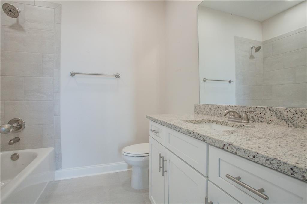 388 Maple View Drive Carrollton, GA 30117 - Photo 14 of 18 a bathroom with a granite countertop sink a toilet and bathtub
