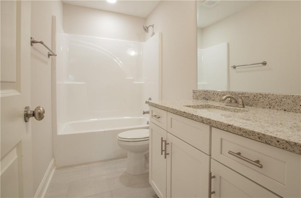 388 Maple View Drive Carrollton, GA 30117 - Photo 15 of 18 a bathroom with a granite countertop sink a toilet and shower