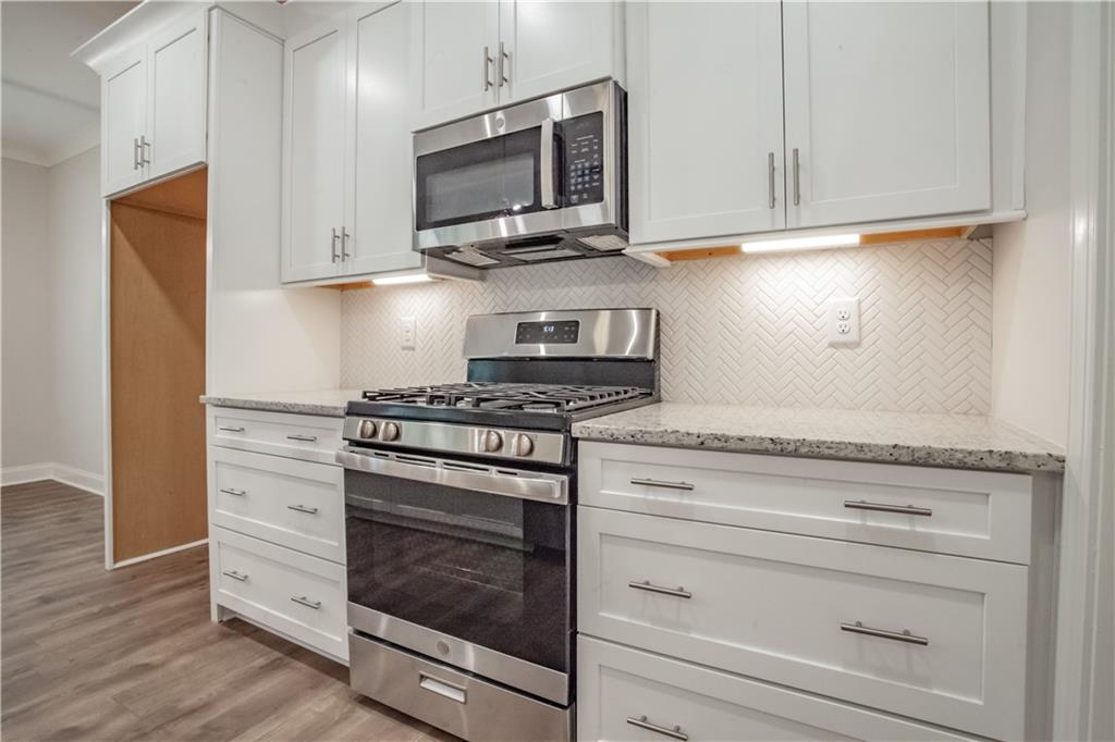 388 Maple View Drive Carrollton, GA 30117 - Photo 6 of 18 a kitchen with stainless steel appliances granite countertop a stove microwave and cabinets