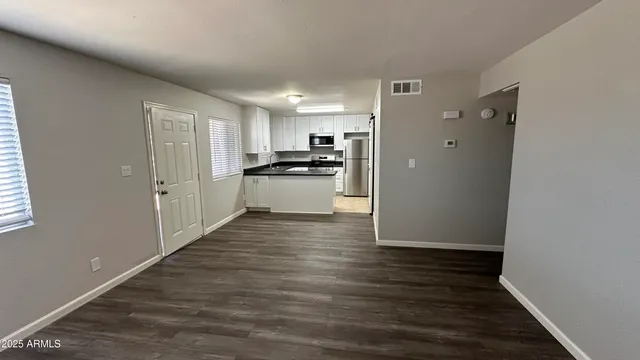 a kitchen with wooden floor and stainless steel appliances