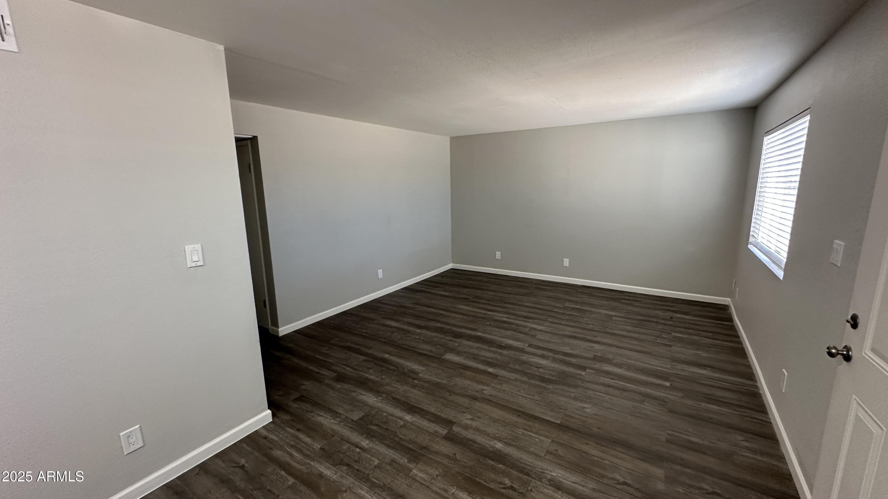 17847 North 40th Street, Unit 1 Phoenix, AZ 85032 - Photo 4 of 12 wooden floor in an empty room with a window
