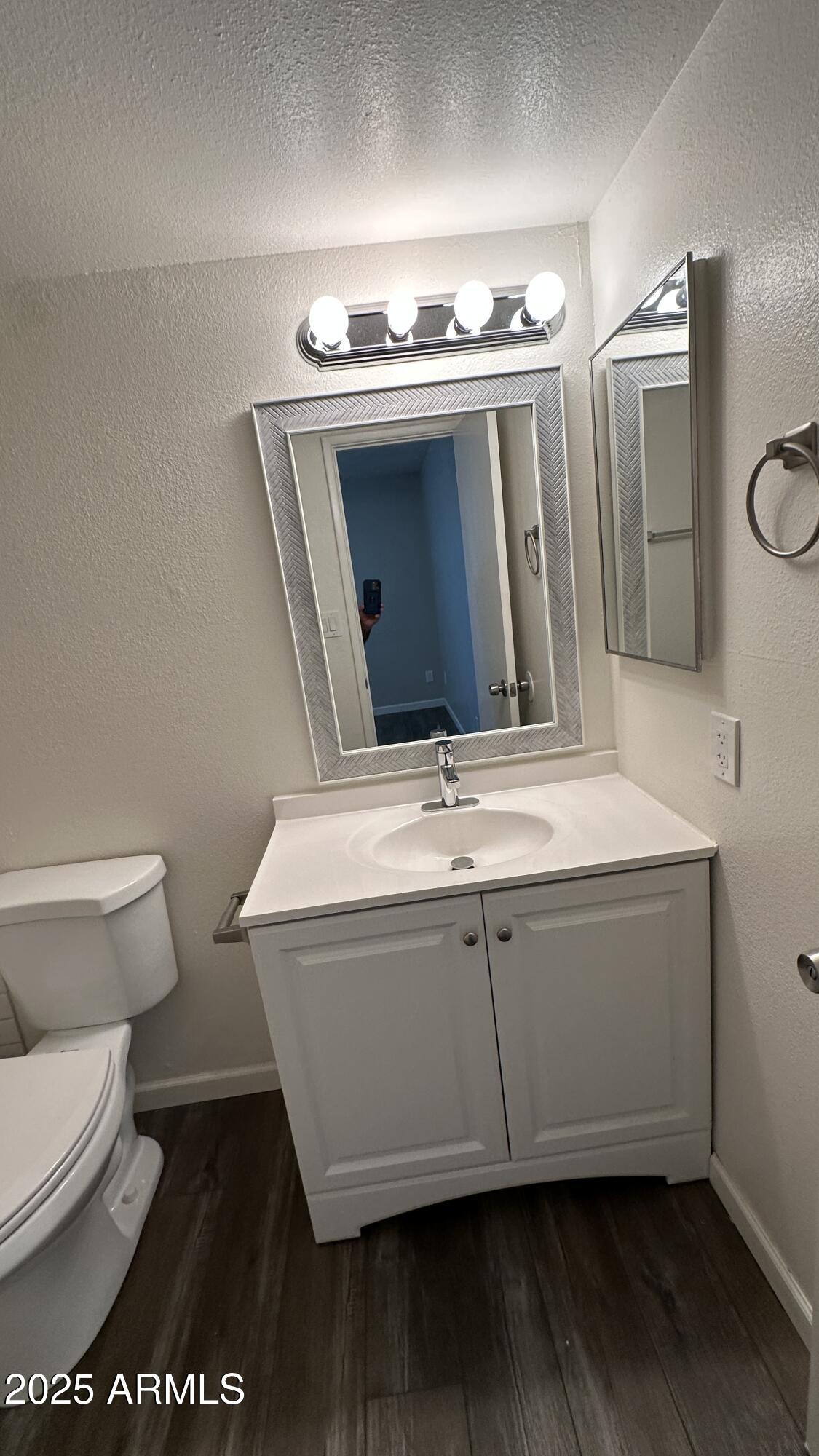 17847 North 40th Street, Unit 1 Phoenix, AZ 85032 - Photo 9 of 12 a bathroom with a granite countertop toilet sink and mirror