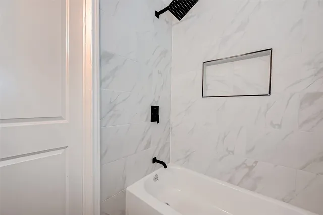 a white bath tub sitting next to a white sink and vanity