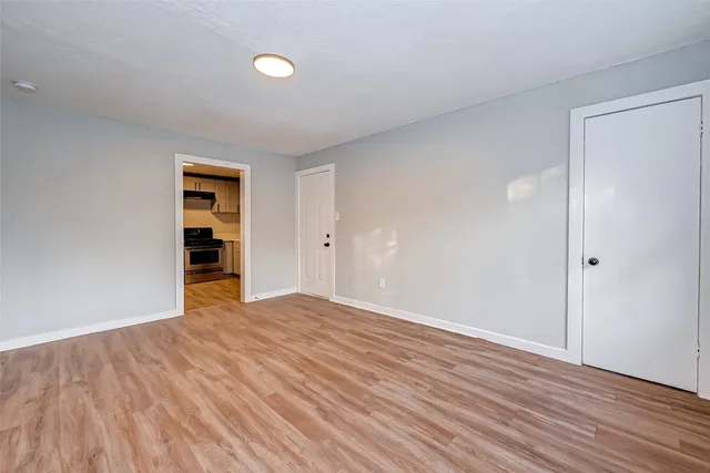 an empty room with wooden floor and closet