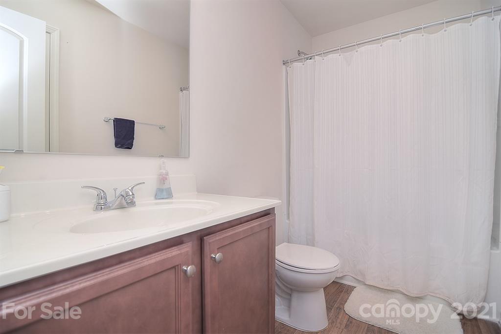 607 Hunley Street Monroe, NC 28112 - Photo 18 of 29 a bathroom with a granite countertop sink a toilet and a mirror