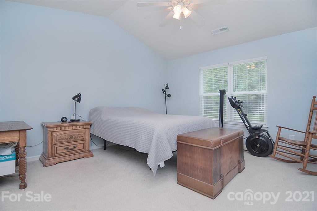 607 Hunley Street Monroe, NC 28112 - Photo 20 of 29 a bed room with a bed and a chandelier