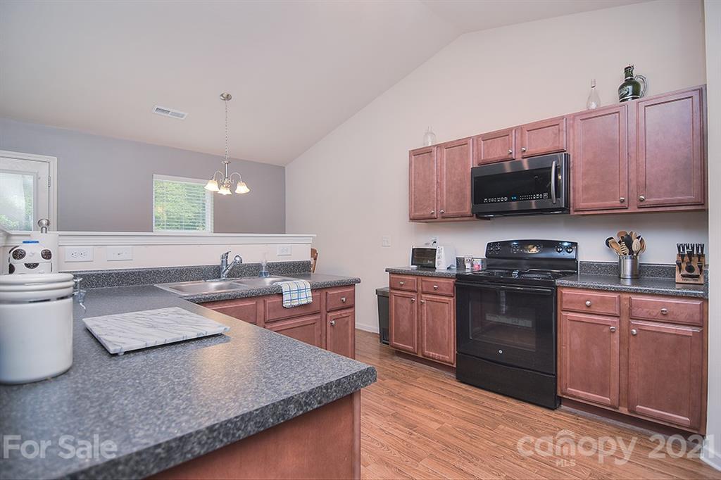 607 Hunley Street Monroe, NC 28112 - Photo 3 of 29 a kitchen with stainless steel appliances granite countertop a sink stove and microwave