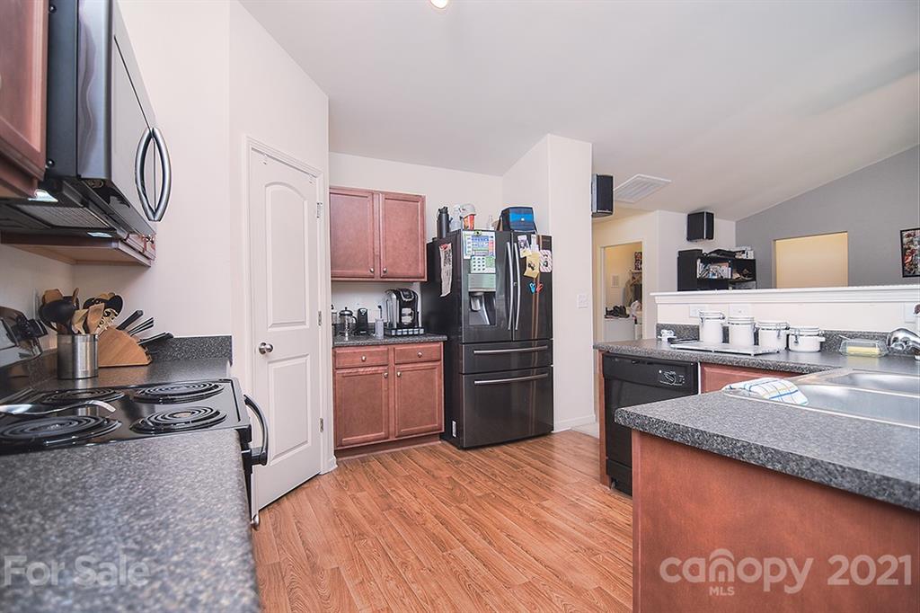 607 Hunley Street Monroe, NC 28112 - Photo 4 of 29 a kitchen with stainless steel appliances granite countertop a refrigerator a stove and a sink