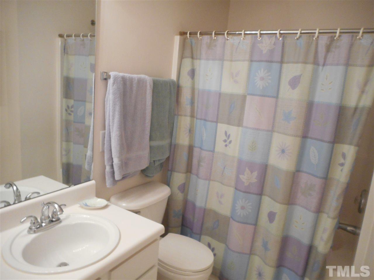 8161 Rhiannon Road Raleigh, NC 27613 - Photo 14 of 22 a white toilet sitting next to a bathroom sink