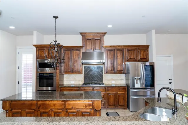 a kitchen with a refrigerator and a stove top oven
