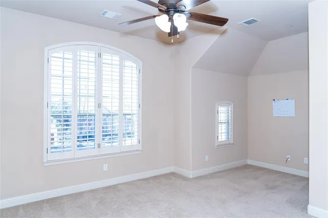 an empty room with a ceiling fan and a fan