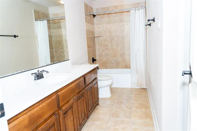 an empty room with a ceiling fan and a bathroom