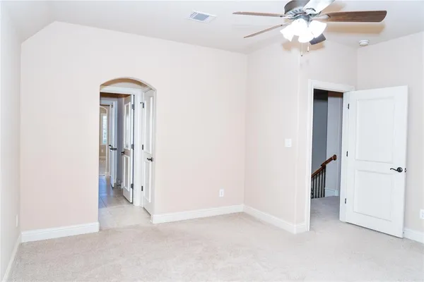 an empty room with a chandelier fan